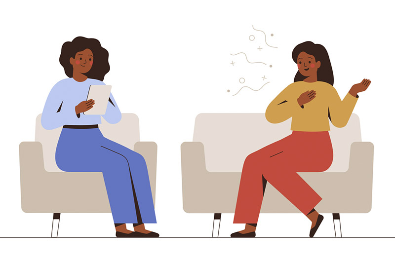 Ilustração de duas mulheres conversando. Elas estão sentadas em poltronas bege. Uma delas tem cabelos escuros de tamanho médio, segura uma prancheta, onde faz anotações, e veste calça e blusa de manga longa azul. A outra gesticula com as mãos, tem cabelos longos escuros e veste calça laranja e blusa de manga comprida amarela